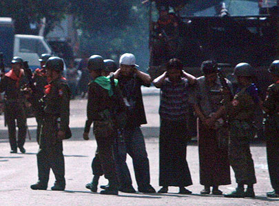 Soldiers arrest three men along a street in Rangoon, Burma in a continuing crackdown against pro-democracy protesters on Saturday Sept. 29, 2007. 